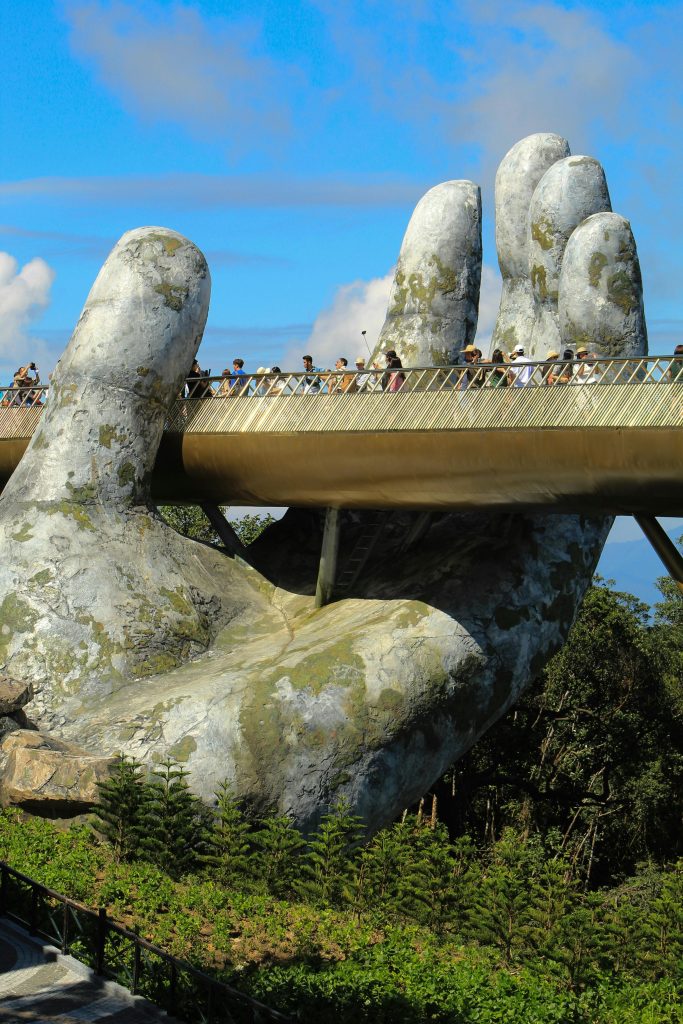 Tourists enjoy a walk on the iconic Golden Bridge in Da Nang, held up by giant stone hands.